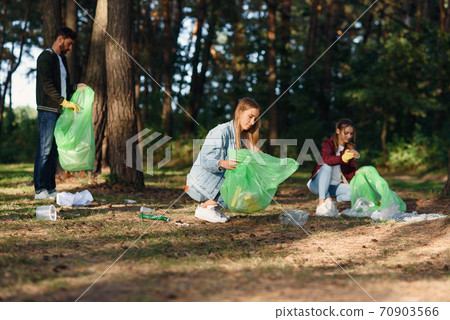 Group of female and male volunteers keep nature clean and picking up rubbish at the forest. Nature lovers concept. Group of female and male volunteers keep nature clean and picking up rubbish at the forest. Nature lovers concept. 70903566