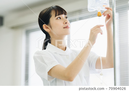 Female nurse preparing for intravenous drip 70904026