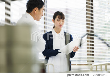Female nurse consulting with a doctor 70904030