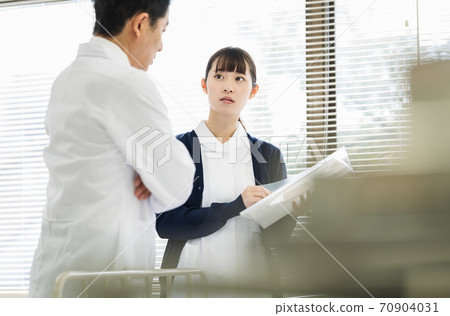 Female nurse consulting with a doctor 70904031