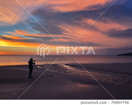 Panoramic view of sunset a man taking photo at Karon beach in Phuket, Thailand Panoramic view of sunset a man taking photo at Karon beach in Phuket, Thailand 70904798