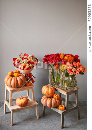 Autumn mood. Set of pumpkins and orange and red flowers for Interior decorations. The work of the florist at a flower shop. Fresh cut flower. 70905278