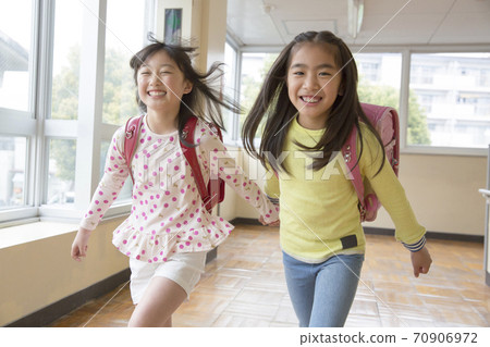 Elementary school students skipping the corridor 70906972