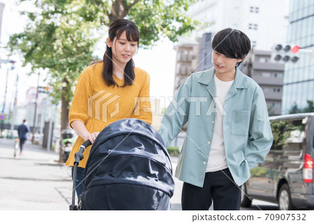 Young Japanese couple pushing a stroller, parenting, family image 70907532