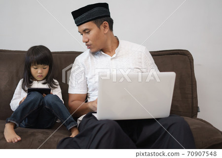 male sitting with his daughter using laptop male sitting with his daughter using laptop 70907548