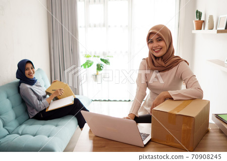 beautiful muslim woman who is very happy and busy working beautiful muslim woman who is very happy and busy working 70908245