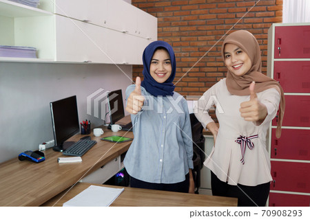 portrait of a beautiful muslim woman who is very happy with her partner with thumbs portrait of a beautiful muslim woman who is very happy with her partner with thumbs 70908293