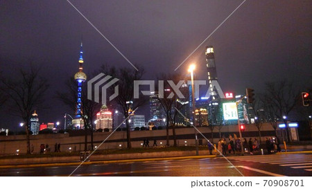 雨後的紫色天空和行道樹的黑色陰影,摩天大樓的燈光在馬路對面流過河 雨後的紫色天空和行道樹的黑色陰影,摩天大樓的燈光在馬路對面流過河 70908701