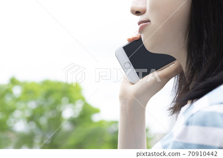 一個年輕的女人在忙著打電話 70910442