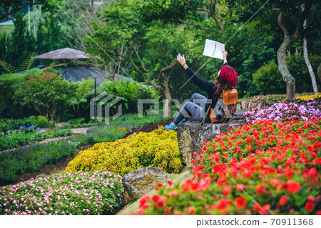 woman travel nature in the flower garden. relax sitting on rocks and reading books In the midst of nature at national park doi Inthanon... 70911368
