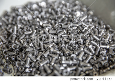 New metal fasteners in the boat in the production of fasteners. Small metal products in oil New metal fasteners in the boat in the production of fasteners. Small metal products in oil 70911438