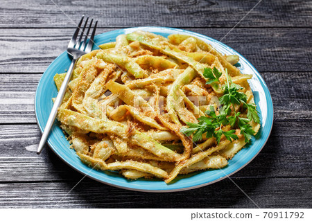 Golden french wax beans on a blue plate, close-up Golden french wax beans on a blue plate, close-up 70911792