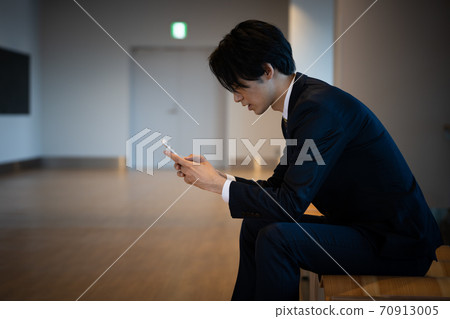 A young businessman with a smartphone 70913005