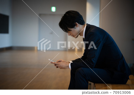 A young businessman with a smartphone 70913006