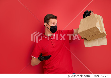 man in red uniform with fast food order isolated on red background man in red uniform with fast food order isolated on red background 70913272