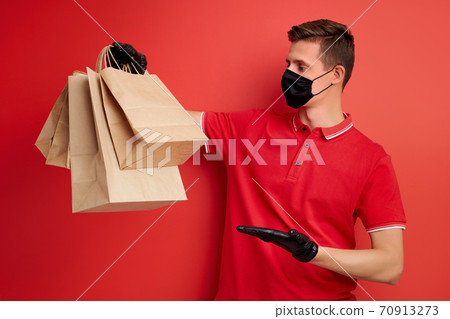handsome caucasian delivery man holding paper bag with takeaway food handsome caucasian delivery man holding paper bag with takeaway food 70913273