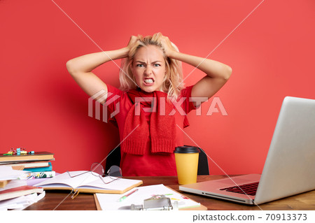young stressed female working with computer laptop in frustration, depression 70913373