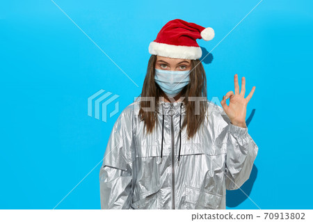 Woman in Santa hat and medical mask in studio 70913802