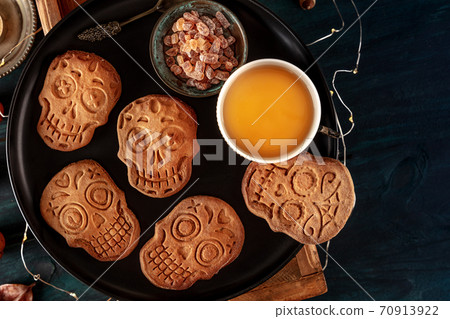 Halloween ginger cookies in the shape of skulls, homemade Dia de los muertos biscuits, top shot with copy space Halloween ginger cookies in the shape of skulls, homemade Dia de los muertos biscuits, top shot with copy space 70913922