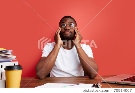 young sad and depressed african man working in stress at office computer desk feeling overwhelmed 70914007