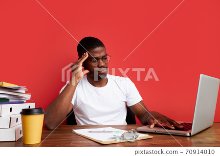 young sad and depressed african man working in stress at office computer desk feeling overwhelmed 70914010