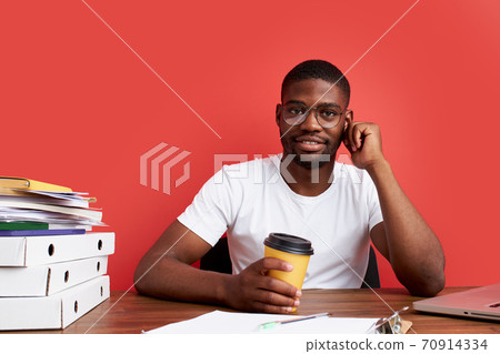 portrait of smiling african man sitting at office desk 70914334