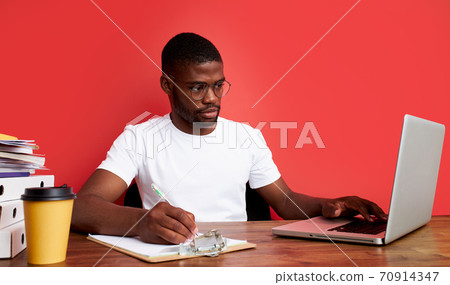 handsome afro american guy is thinking at work, work on laptop 70914347