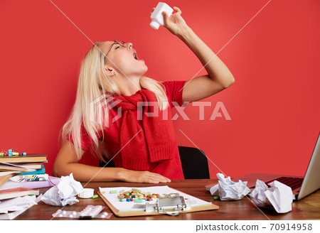 depressed young female is suffering from head ache at work depressed young female is suffering from head ache at work 70914958