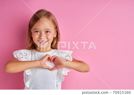friendly kind girl shows heart made from hands at camera friendly kind girl shows heart made from hands at camera 70915160