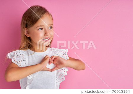 positive kind little girl shows heart made from hands at camera positive kind little girl shows heart made from hands at camera 70915194
