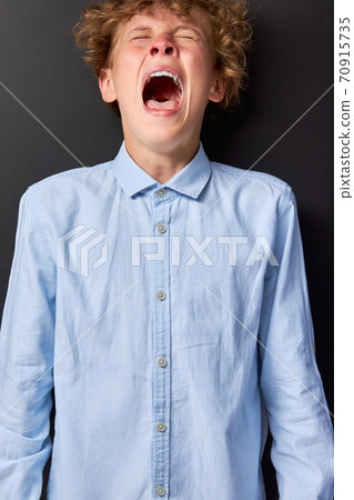 emotional caucasian teen boy is screaming 70915735