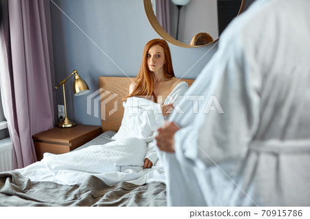 caucasian woman terrified in panic sitting on bed 70915786