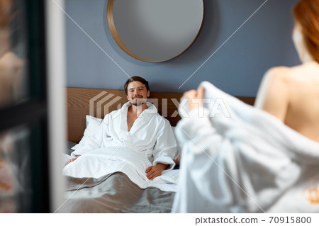 adorable woman is flirting with man in hotel room adorable woman is flirting with man in hotel room 70915800