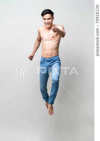 Full length portrait of handsome shirtless Asian man jumping and doing thumbs up Full length portrait of handsome shirtless Asian man jumping and doing thumbs up 70916130