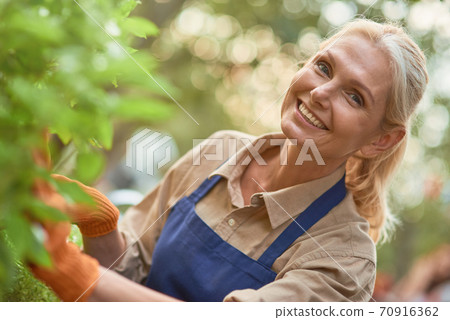 Middle aged caucasian business woman in garden Middle aged caucasian business woman in garden 70916362