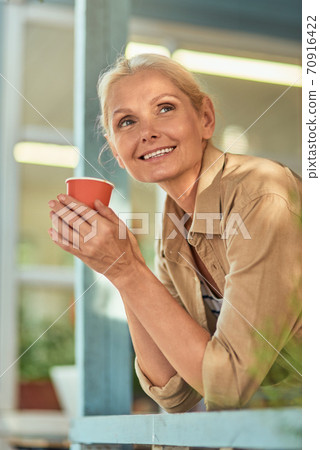 Business woman peeking out of window Business woman peeking out of window 70916422