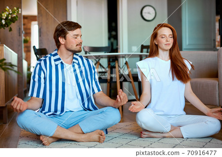beautiful couple practice yoga at home 70916477