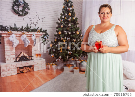 Elegant, overweight woman with Christmas present Elegant, overweight woman with Christmas present 70916795