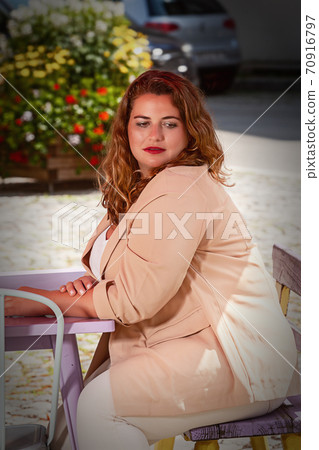 Blonde woman with blazer sitting in a cafe Blonde woman with blazer sitting in a cafe 70916797