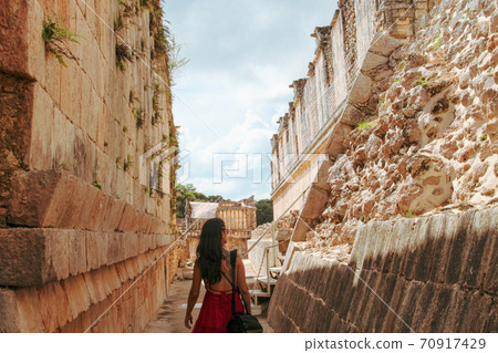 Woman at ruins of the ancient city of Uxmal in Merida, Mexico 70917429
