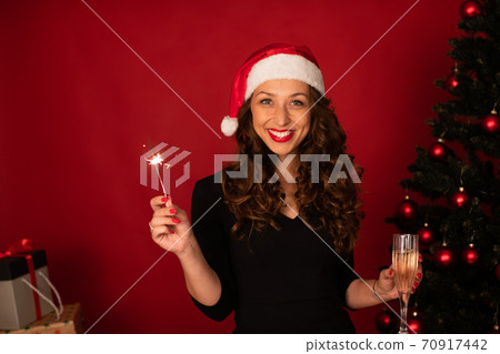 Pretty girl in Santa Claus hat sends Christmas greetings to loved ones by zoom Pretty girl in Santa Claus hat sends Christmas greetings to loved ones by zoom 70917442