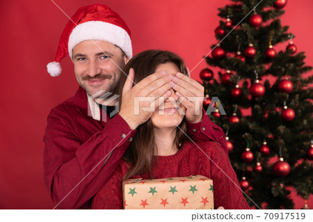Romantic surprise for Christmas, pretty woman receives gift from her boyfriend Romantic surprise for Christmas, pretty woman receives gift from her boyfriend 70917519