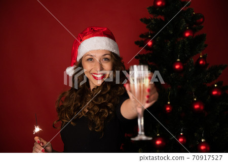 brunette girl in Santa Claus hat sending Christmas greetings to your loved ones brunette girl in Santa Claus hat sending Christmas greetings to your loved ones 70917527