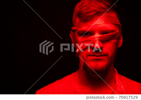 Low key portrait of young bandaged face man segregation and dissociation concept Low key portrait of young bandaged face man segregation and dissociation concept 70917529