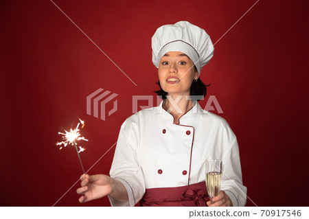 sexy female chef celebrates New Year with glass champagne and Burning sparklers 70917546