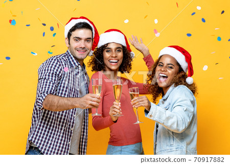 Happy multiracial friends celebrating Christmas drinking champagne together Happy multiracial friends celebrating Christmas drinking champagne together 70917882