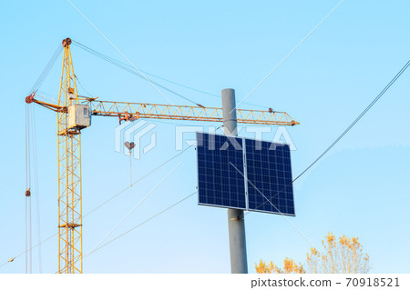 Small solar panel on top electric pole by blue sky 70918521