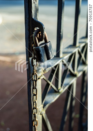 Rusty Chain with a lock on iron gate 70918787