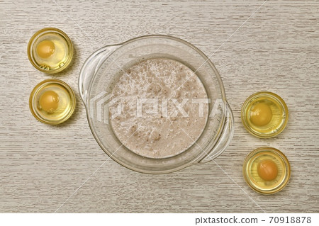 A bowl of fermented diluted yeast four round containers in each of the broken eggs.  70918878