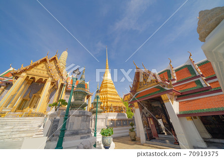 Golden pagoda at Temple of the Emerald Buddha in Bangkok, Thailand. Wat Phra Kaew and Grand palace in old town, urban city. Buddhist temple, Thai architecture. A tourist attraction Golden pagoda at Temple of the Emerald Buddha in Bangkok, Thailand. Wat Phra Kaew and Grand palace in old town, urban city. Buddhist temple, Thai architecture. A tourist attraction 70919375